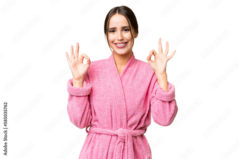 Young beautiful woman in a bathrobe over isolated chroma key background showing an ok sign with fingers Young beautiful woman in a bathrobe over isolated chroma key background showing an ok sign with fingers