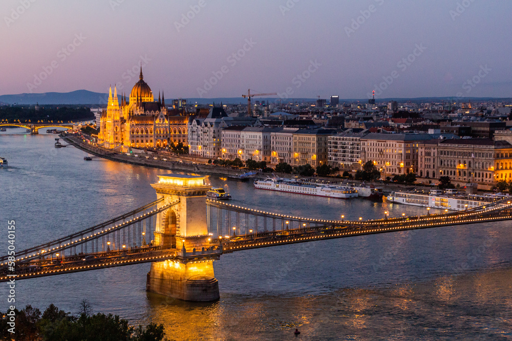 Evening view of Danube river with Szechenyi Lanchid bridge and Hungarian Parliament Building in Budapest, Hungary