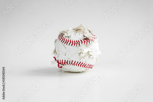 An old baseball that has seen better days. Torn stitches and torn sitting on a clean white background.