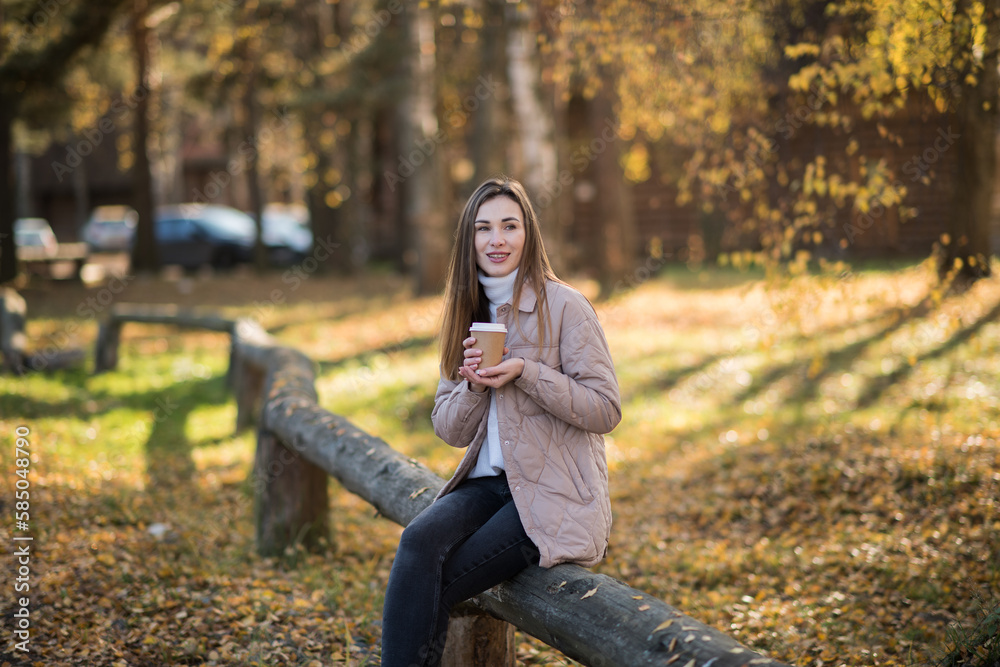 happy young girl walks in the park in autumn and drinks coffee, warm cozy autumn outdoors happy young girl walks in the park in autumn and drinks coffee, warm cozy autumn outdoors