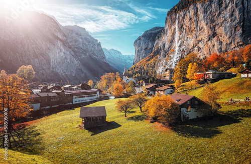 Wonderful autumn landscape. Lauterbrunnen village with awesome waterfall Staubbach and Swiss Alps in the background. Popular travel destination. Iconik location of Switzerland. photo