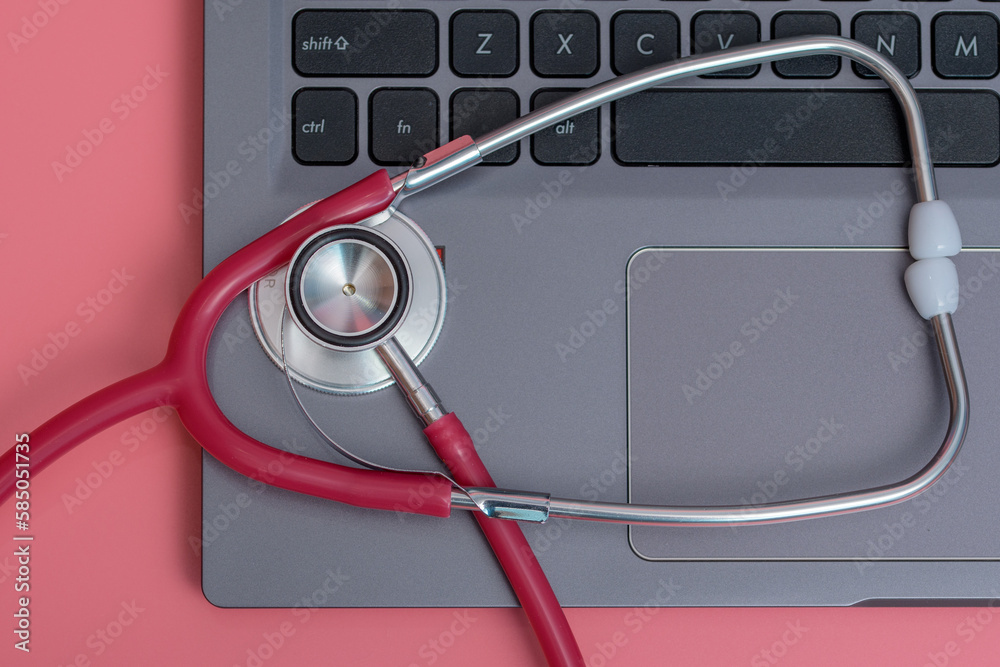 Czerwony stetoskop medyczny na laptopie - obrazy, fototapety, plakaty 