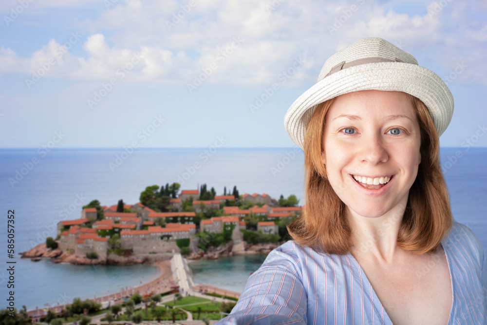 tourist taking selfie with landmarks,tourist international trip,tourism and travel, happy woman in hat taking photo with Sveti Stefan island in Montenegro, travel snapshot