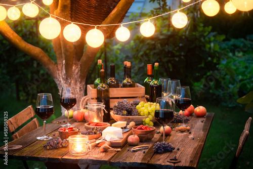 Rustic table with wine and appetizers in the summer evening