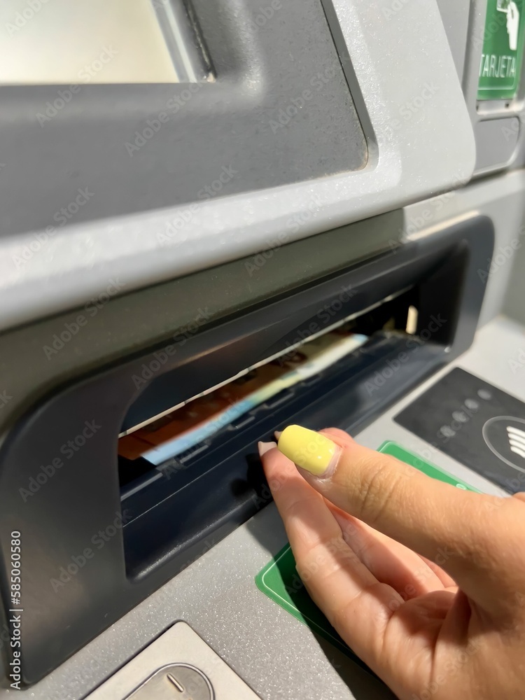 Close up of hands withdrawing money from the ATM. Unrecognizable people withdrawing money from an ATM. Electronic money withdrawal concept Close up of hands withdrawing money from the ATM. Unrecognizable people withdrawing money from an ATM. Electronic money withdrawal concept