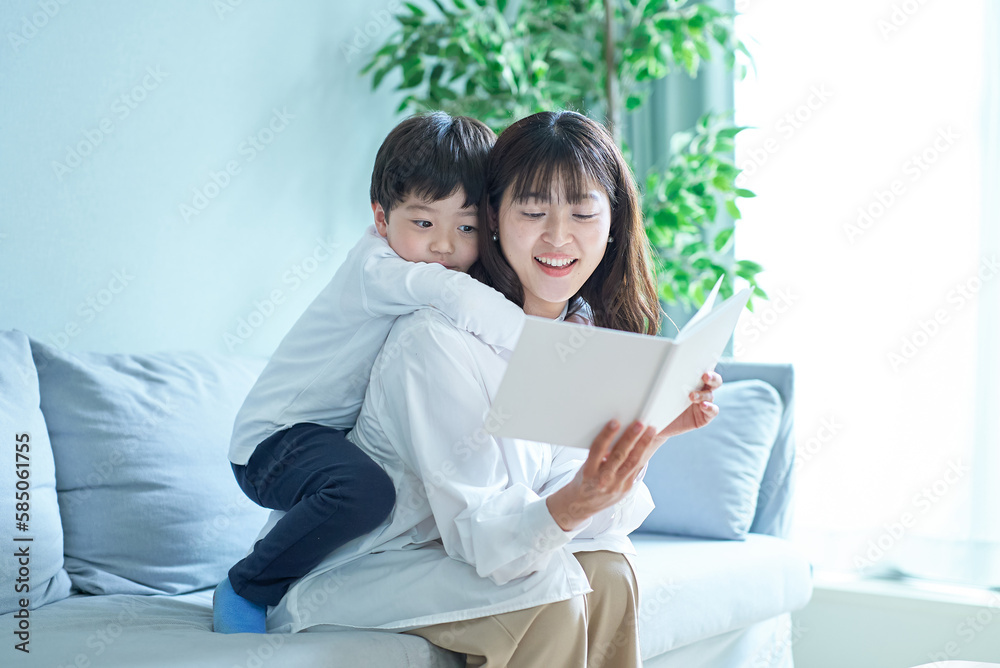 ソファに座って絵本を読む親子 ソファに座って絵本を読む親子