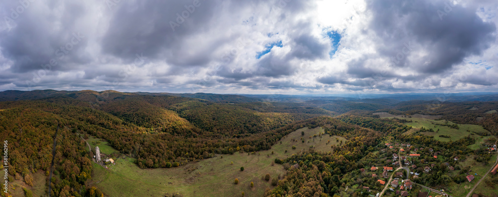 Panoramic Aerial View view of mountain hills. Hilltops covered with autumn forest.