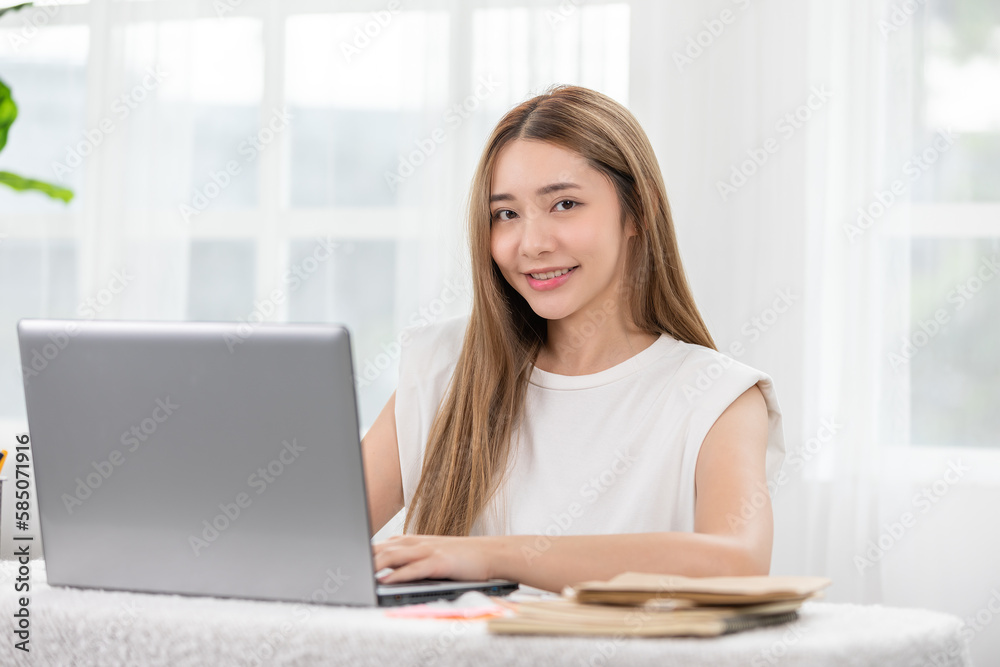 Modern and successful Asian woman working on her laptop with a bright smile. Embodies productivity, efficiency, Balance between work and happiness. For promoting career advancement and technology Modern and successful Asian woman working on her laptop with a bright smile. Embodies productivity, efficiency, Balance between work and happiness. For promoting career advancement and technology