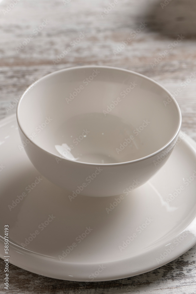 empty white plate on white wooden table empty white plate on white wooden table