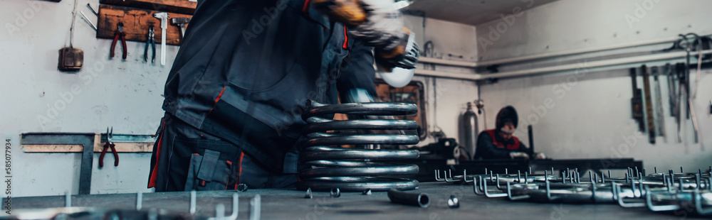 Locksmith in special clothes and goggles works in production. Metal processing with angle grinder. Sparks in metalworking. Locksmith in special clothes and goggles works in production. Metal processing with angle grinder. Sparks in metalworking.