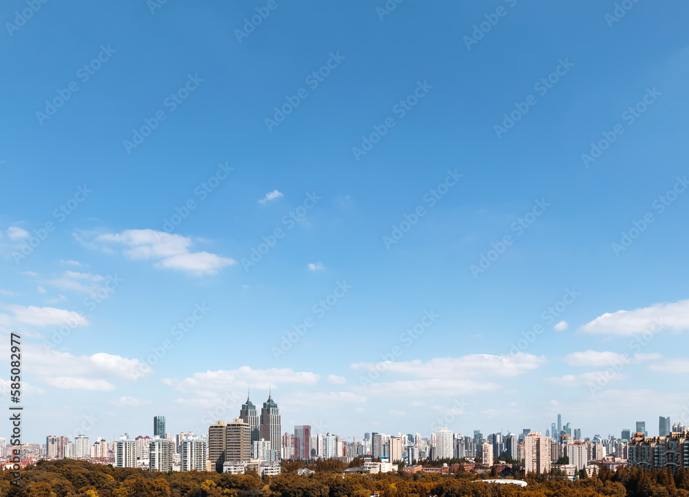 Urban skyline with blue sky and white clouds.	