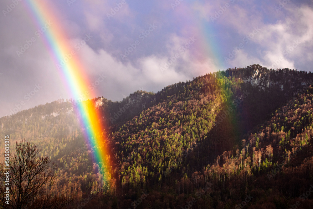 Rainbow in Jura Mountains. Scenic landscape with duble rainbow and mountain view, early spring weather. Swiss Jura.