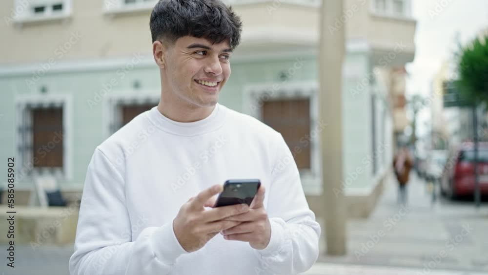 Young hispanic man using smartphone smiling at street Young hispanic man using smartphone smiling at street
