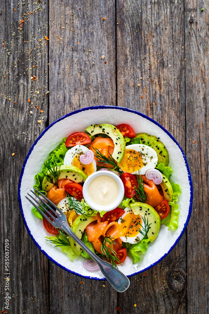 Salmon salad - smoked salmon, hard boiled eggs, avocado and leafy greens on wooden table
Salmon salad - smoked salmon, hard boiled eggs, avocado and leafy greens on wooden table