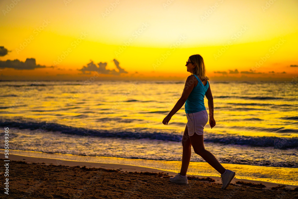 Beach holiday - beautiful woman walking, running on sunny, tropical beach 

