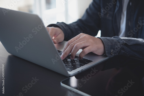 Business man hands typing on laptop computer keyboard and surfing the internet on office table, online working, business and technology, internet network communication concept, close up
