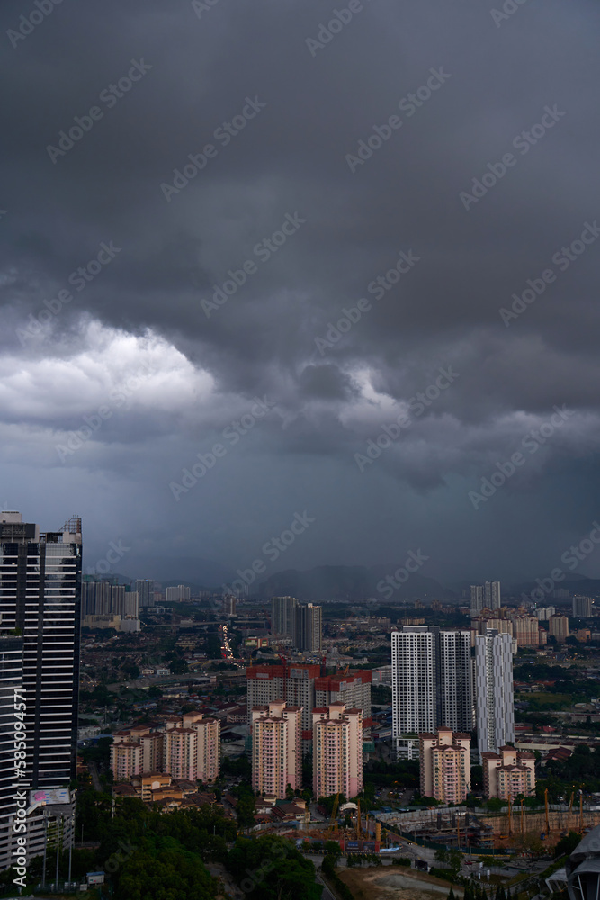 A black storm cloud of rain over the town. Bad weather conditions.