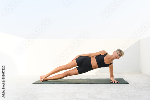 Focused handsome young female doing plank core exercise