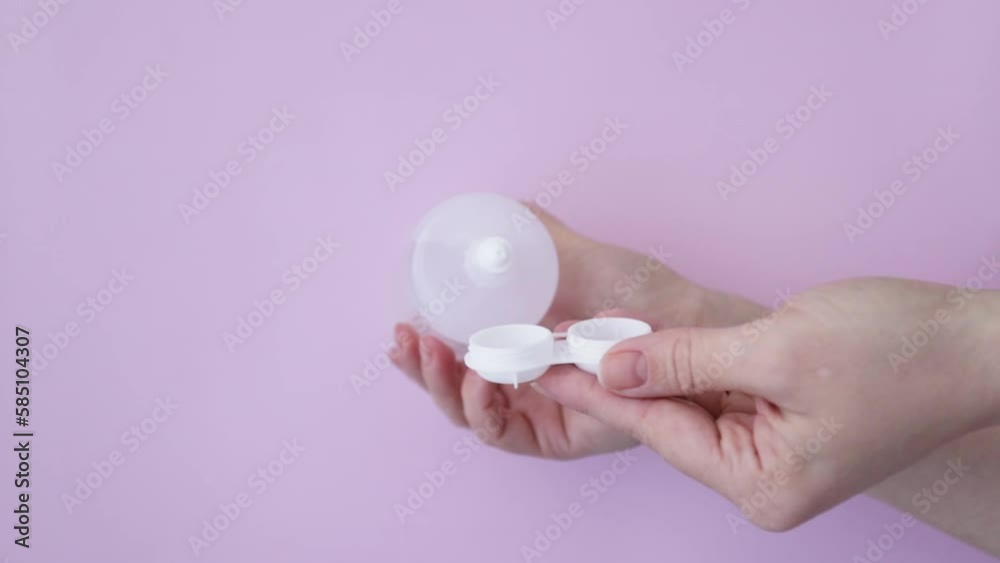 ophthalmic lenses cleaning,hands pour storage and rinsing solution from bottle into container ophthalmic lenses cleaning,hands pour storage and rinsing solution from bottle into container