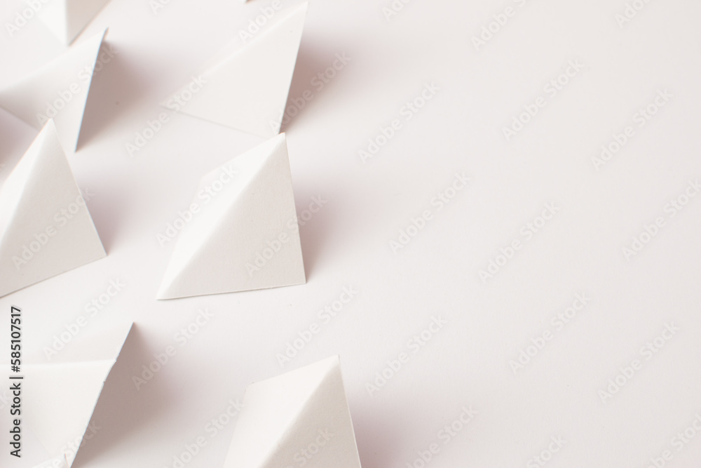Close up 3d white triangle shapes on white background with empty space Close up 3d white triangle shapes on white background with empty space