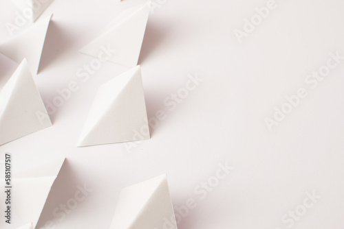 Close up 3d white triangle shapes on white background with empty space