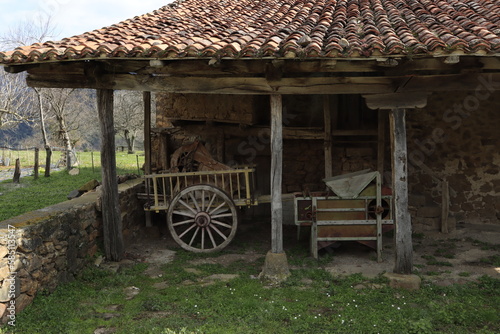 Carro de bueyes en porche con tejado rojo y columnas de madera
