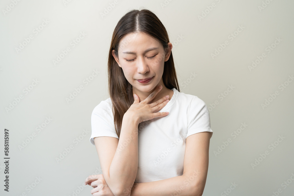 Woman feeling sore throat and touching her neck isolated on background Woman feeling sore throat and touching her neck isolated on background