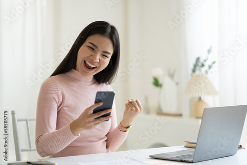 Young pretty Asian woman impressed with a good news, raised fists scream yes, celebrating success on her own. © PaeGAG