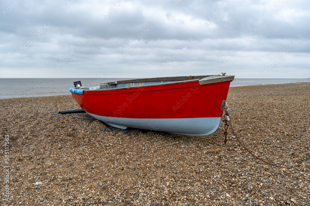 Isolated wooden fishing boat on the stony beach in Dunwich on the Suffolk coast
