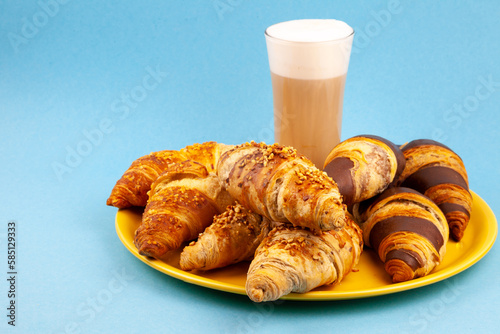 Chocolate croissants or croissant with nut crumbs on a plate. Delicious breakfast on the table. Tasty sweet baking dessert for coffee. Food background. Fresh buttery croissants rolls. Copy space