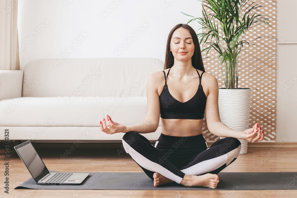 mental health concept. meditation at home. girl meditates and performs breathing practices with a laptop