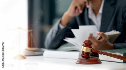Businesswoman female lawyer reading book, wooden judge gavel on the table.