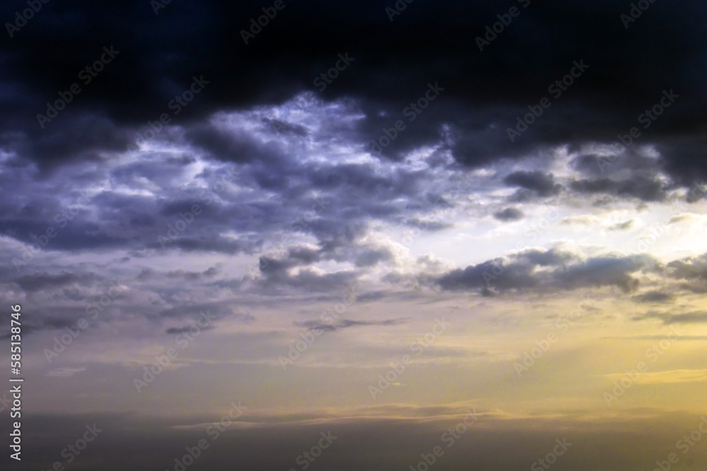 Dark cloudy sky with sunlight background.  Cloudscape background.  Dramatic sky with dark fluffy clouds background. 