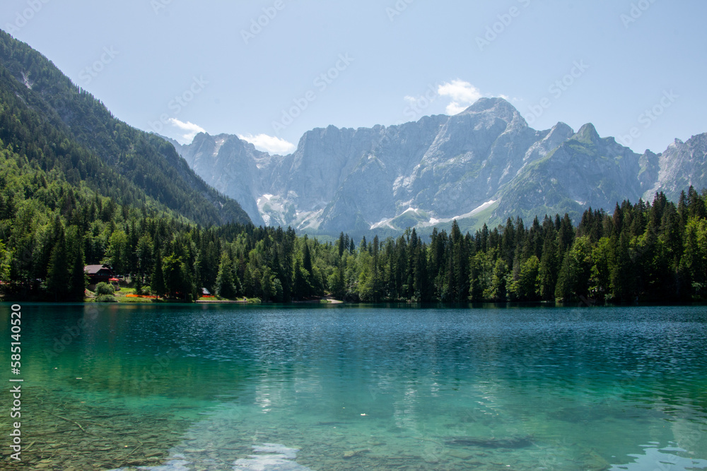 View of Lago Inferiore die Fusine in the Julian Alps of northeastern Italy with the dramatic rock face of Mount Mangart in the background