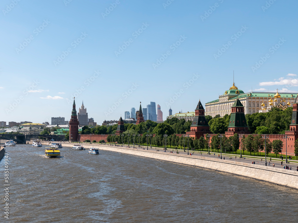 Obraz premium MOSCOW, RUSSIA - MAY 22, 2022: View of the Moscow Kremlin from the Moscow river. Red brick towers and Bell Tower Of Ivan The Great