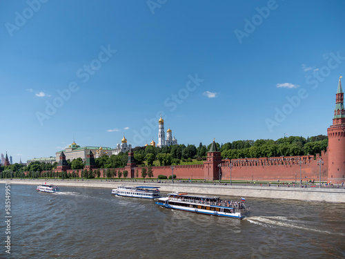 MOSCOW, RUSSIA - MAY 22, 2022: View of the Moscow Kremlin from the Moscow river. Red brick towers and Bell Tower Of Ivan The Great