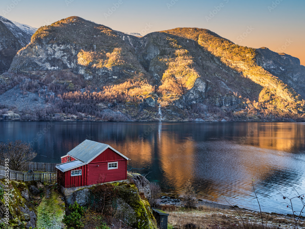 Traditional Norwegian red house on Aurlandsfjord during autumn in Vestland, Sogn, Norway