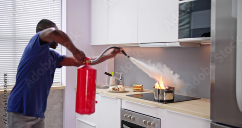 Man Using Fire Extinguisher To Stop Fire