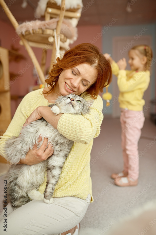 Happy woman spending time with cat in animal shelter Happy woman spending time with cat in animal shelter