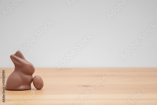 Chocolate bunny and chocolate eggs on a wooden table. Easter background.