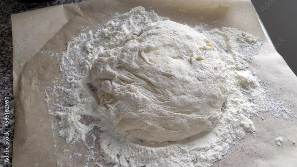 Ball of bread dough on top of flour on baking sheet Ball of bread dough on top of flour on baking sheet