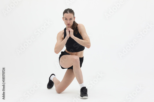 young athletic woman doing lunge exercise isolated on white background  front view