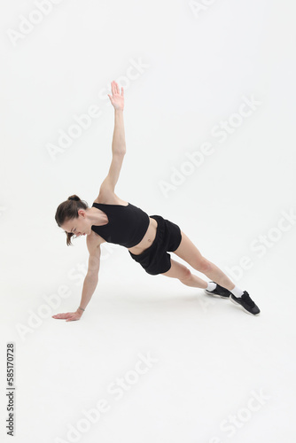 young sporty woman doing advanced plank fitness exercise isolated on white background