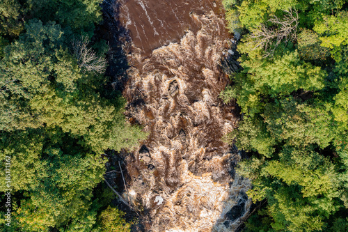 Muddy river rapids seen from the air in a nadir view.