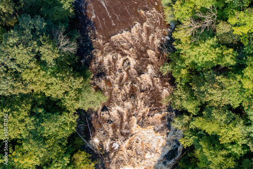 Muddy river rapids seen from the air in a nadir view. photo