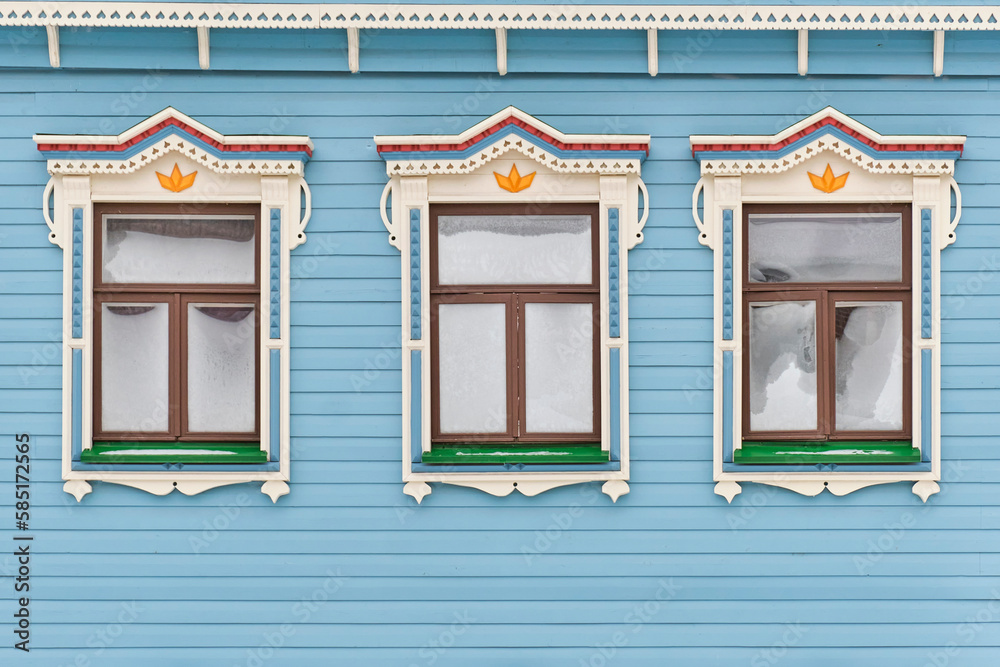 Frozen windows with carved wooden architraves. Facade of typical merchant tatar house.