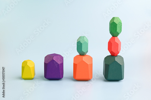 Concept of growth. Multicolored wooden blocks arranged on a blue background.