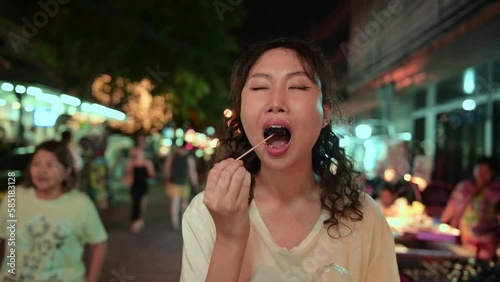 Beautiful young Asian tourist woman on vacation sightseeing and exploring at Khao San road at night in Bangkok city, Thailand, Holidays and traveling concept.
