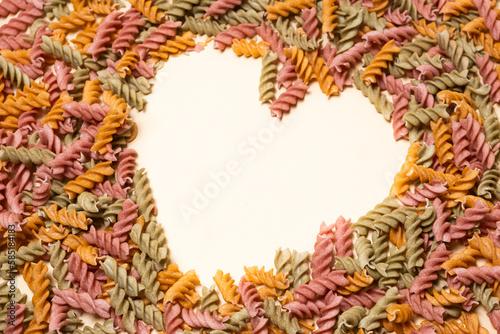 Rice vegetable pasta on a white background, laid out in the shape of a heart, a place for text. photo