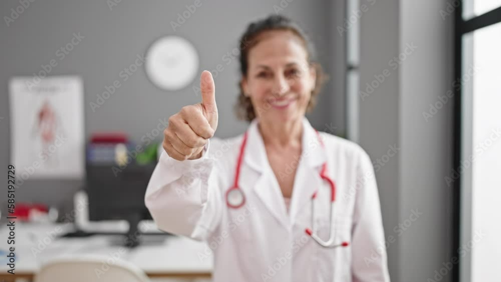 Middle age hispanic woman doctor doing thumb up at clinic Middle age hispanic woman doctor doing thumb up at clinic